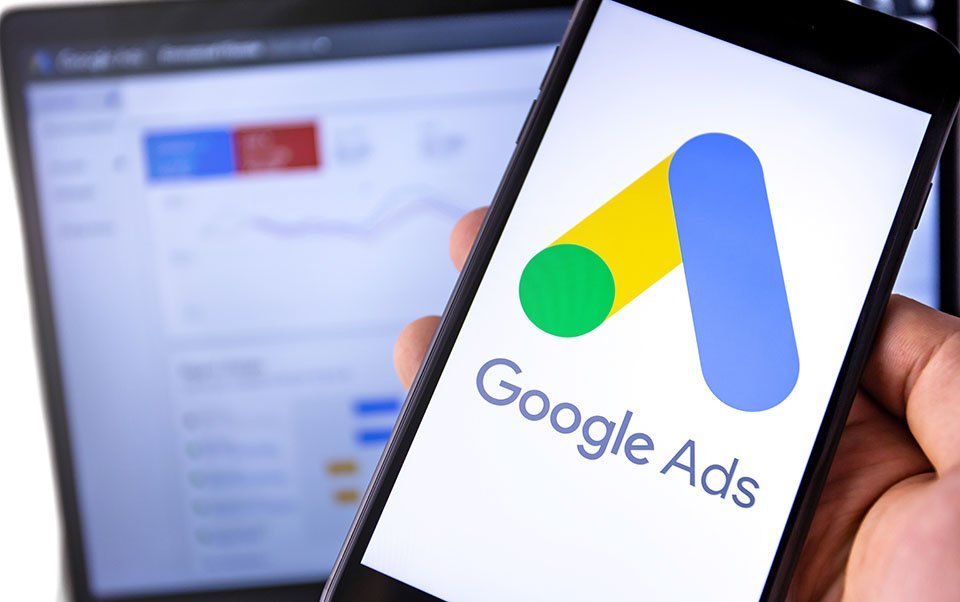 smartphone with Google Ads on the screen and display notebook ba